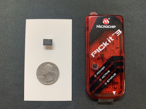 PIC12F1822 Microcontroller next to a PICkit programmer and a quarter for scale